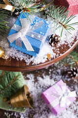 Christmas composition with presents and decoration on wooden cake stand. Christmas greeting card.