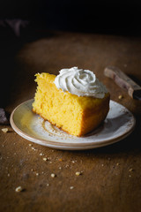 Pumpkin spice cake with whipped cream on plate. Vertical