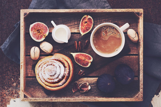 Breakfast tray - cup of coffee with cream, fresh bakery, ripe figs and pecan nuts
