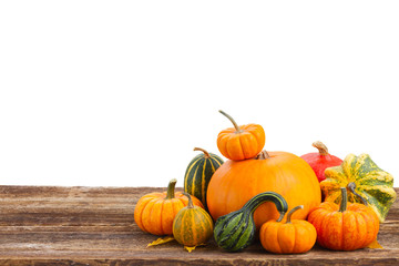 pile of raw orange pumpkins on wooden table border isolated on white background