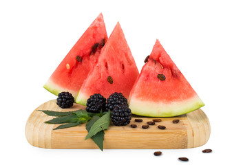 The triangular slices of watermelon, seeds, blackberries and mint. On a wooden board. Isolated on...