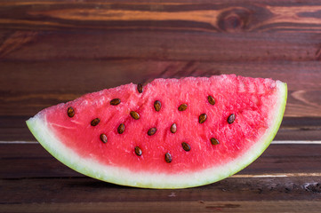 Fototapeta na wymiar Slice of watermelon with seeds. On a wooden background.