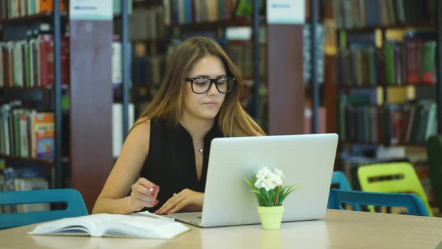 girl student working at a computer in the library