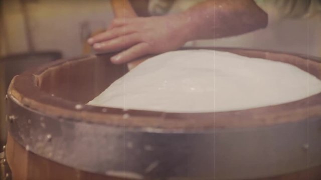 A man makes the traditionally Italian cheese. Video with vintage effect