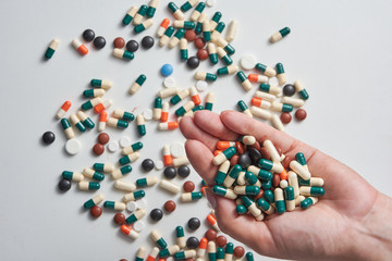 womans hand holding a lot of pills