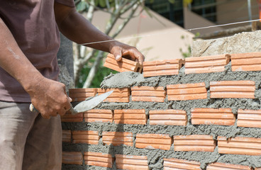 Workers masonry Clay brick to wall.