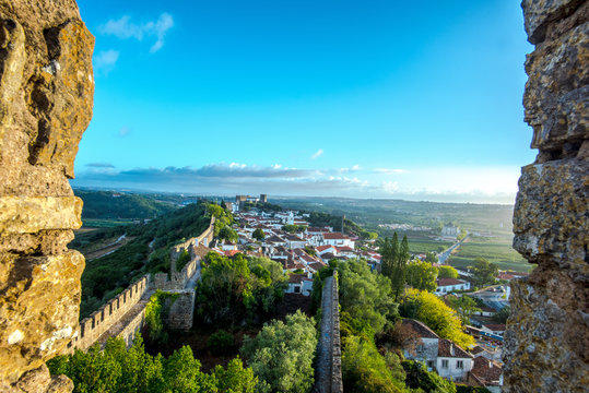Obidos, Portugal : Cityscape of the town with medieval houses, wall and the Albarra tower. Obidos is a medieval town still inside castle walls, and very popular among tourists.