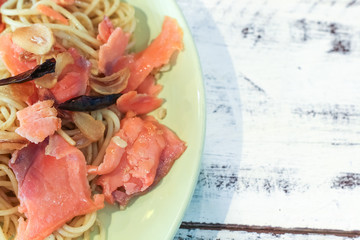 close-up of plate of pasta and smoked salmon with copy space