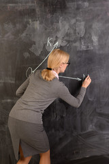 Young teacher stands at the blackboard, is a lesson