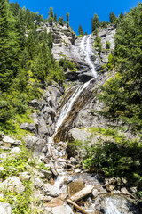 Fototapeta na wymiar Felswand mit Wasserfall im Maltatal in Kärnten Österreich unter blauem Himmel