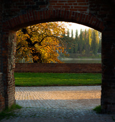 autumn sunset behind the old brick castle gate