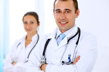 Fototapeta premium Cheerful smiling male doctor with medical staff at the hospital