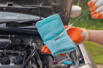 Mechanic checking the oil level of a car engine, normal levels .