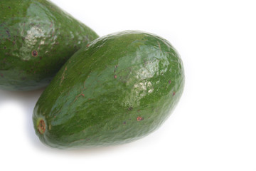 due avocado verdi e interi isolati su sfondo bianco