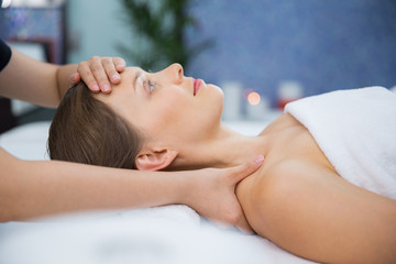 Young woman enjoying face and collar area massage