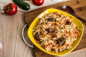 Photo of dish of uzbek pilaf made of rice and carrots, meat and onions