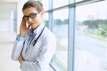 Medical physician doctor woman over blue clinic background.