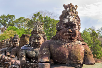 Stone sculptures near South Gate of Angkor Thom from outside the city. Angkor Wat. Siem Reap, Cambodia. UNESCO World Heritage Site.