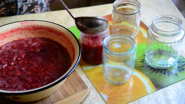 Woman puts handmade Strawberry jam in jar