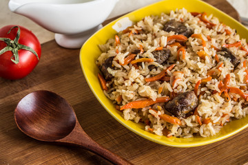 Photo of dish of uzbek pilaf made of rice and carrots, meat and onions