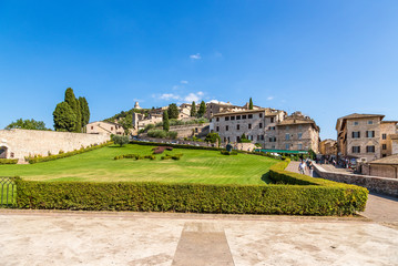 Fototapeta premium Assisi, Italy. The city view with the lawn in front of St. Francis Cathedral: Tau cross and motto of the Franciscan «Pax et Bonum»