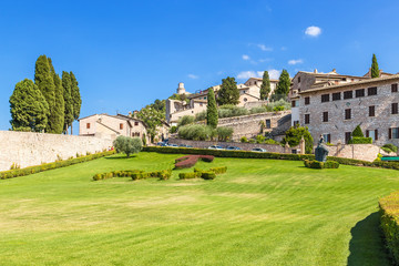Assisi, Italy. The lawn in front of St. Francis Cathedral: Tau cross and motto of the Franciscan...