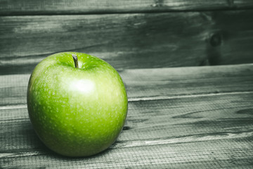 Green apple on grunge gray wooden table.