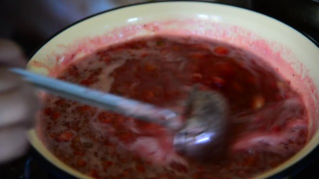Housewife takes foam with strawberry jam