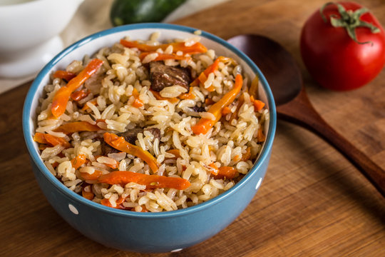 Photo of dish of uzbek pilaf made of rice and carrots, meat and onions