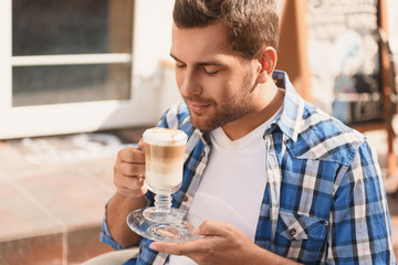 Handsome man relaxing with cup of latte