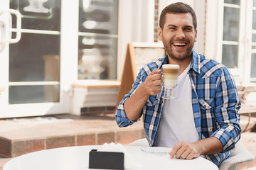 Handsome man relaxing with cup of latte