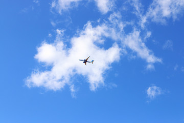 Fototapeta na wymiar Under view of modern passenger airliner in blue sky with white c