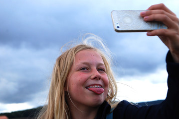 YOUNG GIRL WITH BRACE MAKING AN TONGUE OUT SELFIE