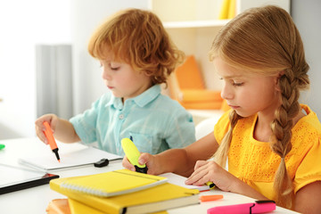 little preschoolers using markers on copybook