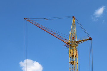 Part of stationary hoist on construction site, blue sky and whit