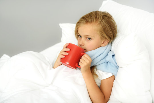 girl with flu holding warm beverage