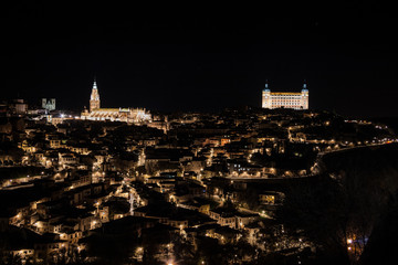 Naklejka premium Vista nocturna de Toledo con el Alcazar y la catedral de Santa María al fondo