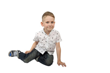 Little boy sits on floor isolated on white background with shadow and free space for text message
