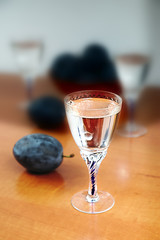 Glass of homemade plum brandy with plums