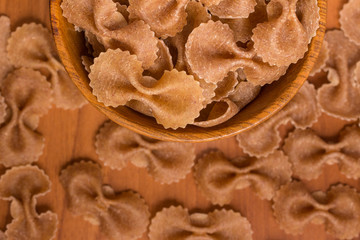 Wholegrain Farfalle into a bowl. wholemeal. Integral.