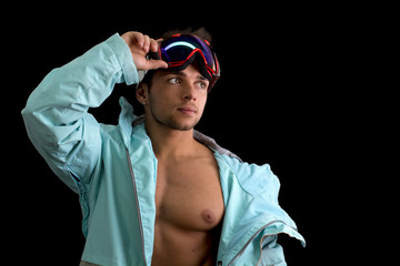 Muscular skier or snowboarder with open jacket on naked muscular torso, isolated on black