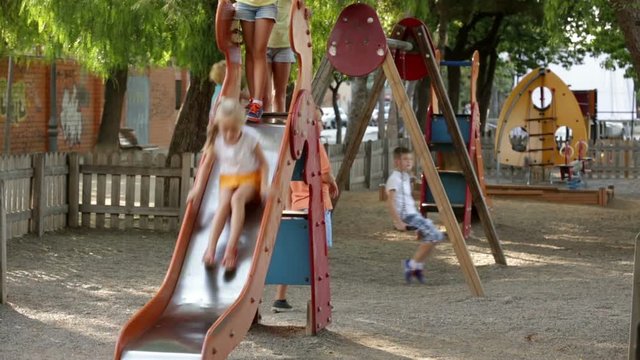 Smiling kids in school age playing together on playground outdoors