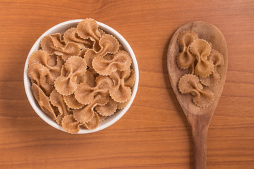 Wholegrain Farfalle into a bowl. wholemeal. Integral.