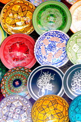 Traditional colorful Moroccan faience pottery dishes in a typical ancient shop in the Medina's souk of hte ancient imperial city of Marrakech, Morocco.