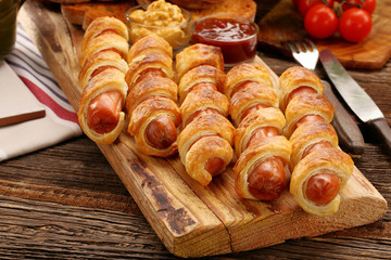 Rolled hot dog sausages baked in puff pastry - 122431137