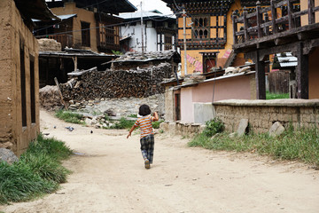 The back of a boy running through the village