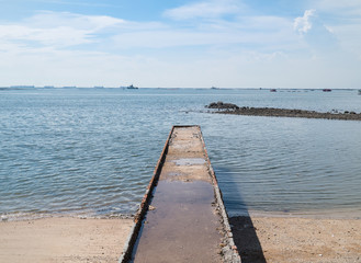 Fototapeta na wymiar Stone brick jetty to the sea