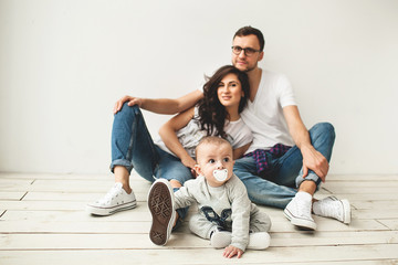 Hipster father, mother holding cute baby boy over white background