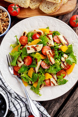 Grilled Halloumi Cheese salad witch orange, tomatoes and lettuce. healthy food