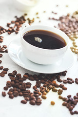 Cup of coffee with steam and coffee beans, closeup, selective focus